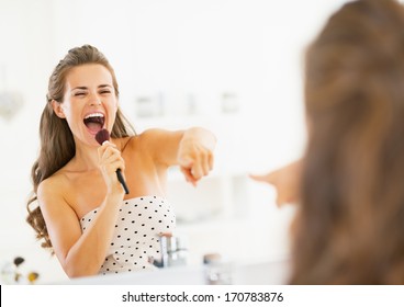 Happy Young Woman Singing In Makeup Brush In Bathroom