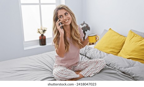 Happy young woman sipping coffee while comfortably talking on her smartphone in bed, soaking in the morning tranquility of her cozy bedroom - Powered by Shutterstock