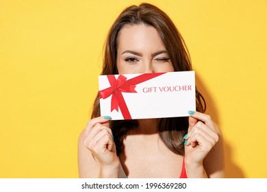 Happy Young Woman Slim Body Wear Striped Red Blue Swimsuit Hold Gift Certificate Coupon Voucher Store Card Isolated On Vivid Yellow Color Background Studio. Summer Hotel Pool Sea Rest Sun Tan Concept