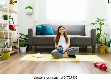 Happy Young Woman Smiling After Finishing Her High Intensity Training At Home. Hispanic Woman Drinking Water And Resting From Working Out