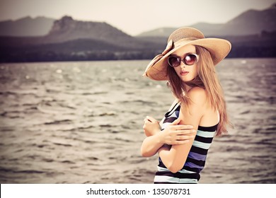 Happy young woman standing face to the wind over beautiful landscape.