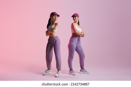 Happy young woman standing next to her metaverse avatar in a studio. Cheerful young woman smiling at the 3D simulation of herself. Young woman exploring virtual reality. - Shutterstock ID 2142734887