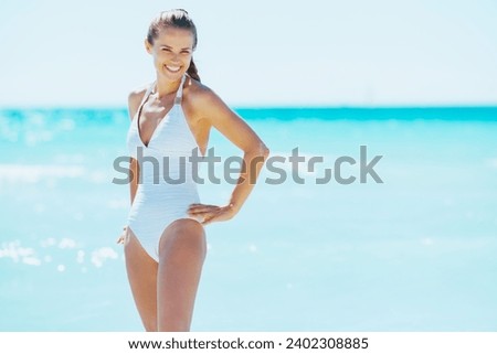 happy young woman standing at seaside