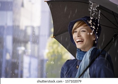 Happy Young Woman Standing Under Umbrella In Rain, Laughing.