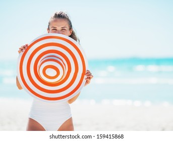 Happy Young Woman In Swimsuit Hiding Behind Beach Hat