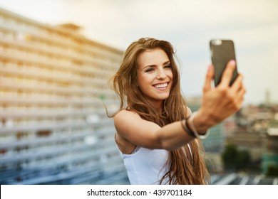 Happy young woman taking selfie on rootfop - Powered by Shutterstock