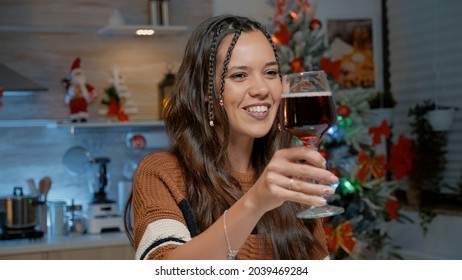 Happy Young Woman Talking On Video Call At Home In Festive Kitchen With Christmas Decorations And Ornaments. Adult Preparing To Bake For Seasonal Dinner Party With Friends And Family