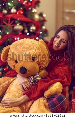 Happy young woman and teddy bear Christmas Present 