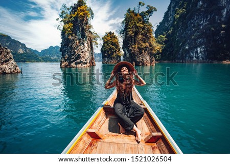 happy young woman tourist in asian hat on the boat at lake 