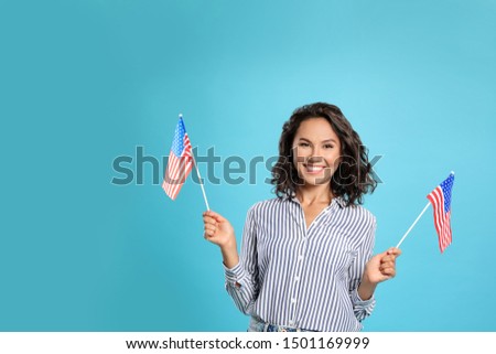 happy young woman with USA flag on blue background. Space for text