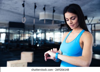 Happy Young Woman Using Activity Tracker In Fitness Gym 