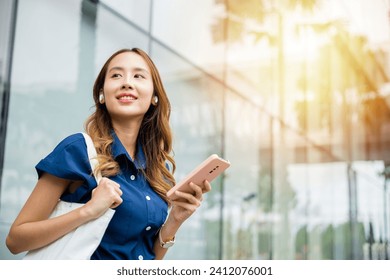 Happy young woman using wireless earbuds and smartphone for virtual chat and social media. This portrait shows a person's modern lifestyle. - Powered by Shutterstock