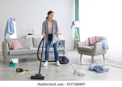 Happy Young Woman Vacuuming Her House After Party, Copy Space. Millennial Female Student Doing College Dorm Room Cleanup After Holiday Celebration. Domestic Duties Concept