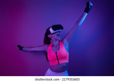 Happy young woman in virtual reality glasses keeping arms outstretched - Shutterstock ID 2179353603