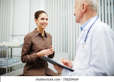 Happy Young Woman Visiting Doctor And Listening To His Advice During Appointment