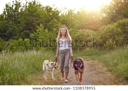 Similar – Image, Stock Photo Blond woman with her two dogs in the countryside