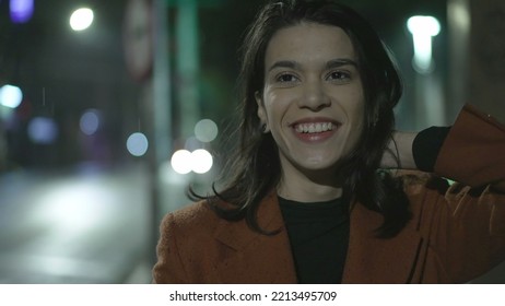 Happy Young Woman Walking In Rain At Night In City Street. Carefree Millennial Businesswoman Walks In Sidewalk In The Evening After Work In Drizzle Alone