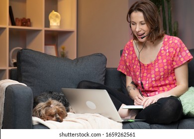 Happy Young Woman Wear Headset Communicating By Conference Call Speak Looking At Computer At Home. Video Chat Job Interview Or Distance Language Course Class With Online Teacher Concept