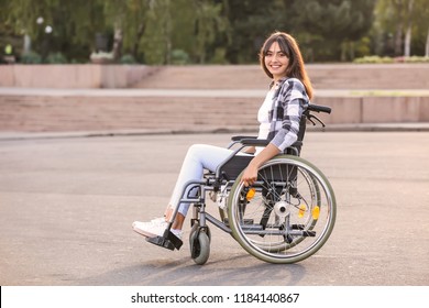 Happy Young Woman In Wheelchair Outdoors