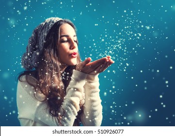 Happy Young Woman With Winter Clothes Blowing Snow