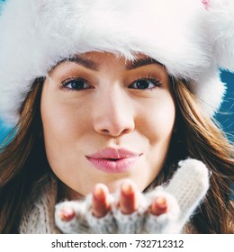 Happy Young Woman With Winter Clothes Blowing A Kiss 