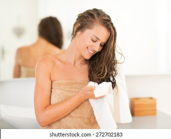 Happy young woman wiping hair with towel in bathroom - Shutterstock ID 272702183