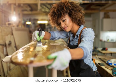 Happy young woman working on surfboard in her workshop
 - Powered by Shutterstock