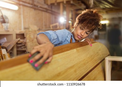 Happy young woman working on surfboard in her workshop
 - Powered by Shutterstock