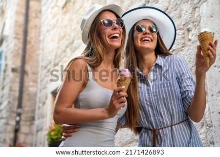 Happy young women friends enjoying ice cream together on summer vacation