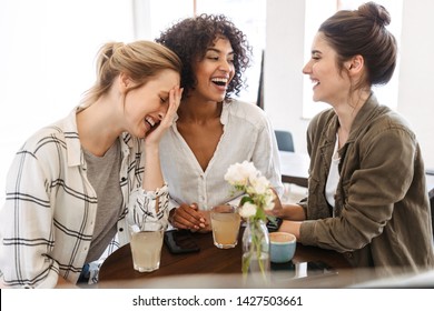 Happy young women friends having coffee break while relaxing at the cafe indoors - Shutterstock ID 1427503661