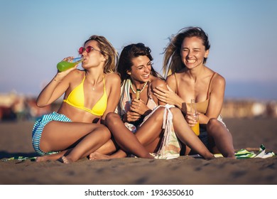 Happy Young Women Sitting On The Beach. Group Of Friends Enjoying On Beach Holiday.