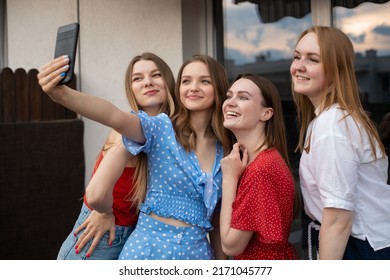 Happy young women standing together on terrace, smiling and taking selfie on smartphone closeup. Having fun and enjoying outdoor recreation. Girls party, hen night, female friendship, summer vacation.