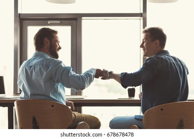 Happy Youthful Guys Cooperating Together At Work In Office