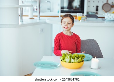 Happylittle Girl Setting The Table For Family Lunch During Holidays. Girl Setting Table. Preschooler Kid Helping Mother To Set Table In Kitchen.