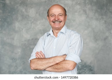 Happysenior Hispanic Man With Crossed Hands Looking Confident At Camera. Studio Shot