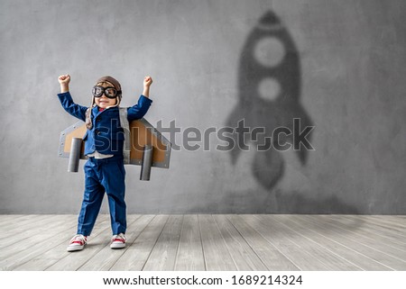 Hapy child wants to become a astronaut. Funny kid dreams of becoming a rocket pilot. Imagination and motivation concept