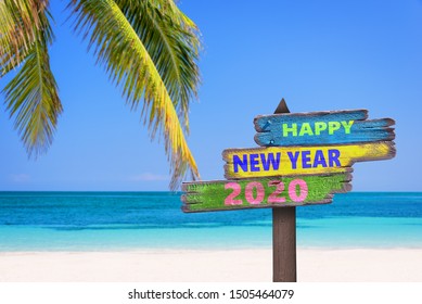 Hapy new year 2020 on a colored wooden direction signs, beach and palm tree background - Powered by Shutterstock