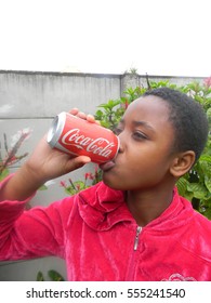 Harare,Zimbabwe,12 April 2016. A  Young  African  Girl  Drinking  Coca-cola From A Can Outside  Her  Home.In  Zimbabwe  Coke  Is  The The  Most Popular Non Alcoholic Drink.