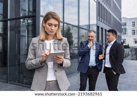 Harassment at work, group of business people outside office building, men discussing behind woman boss's back, gossiping and stalking