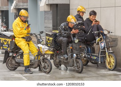 Harbin, Heilongjiang, China - September 2018: Delivery Man On Motor Scooter. Guys Look At Smartphones