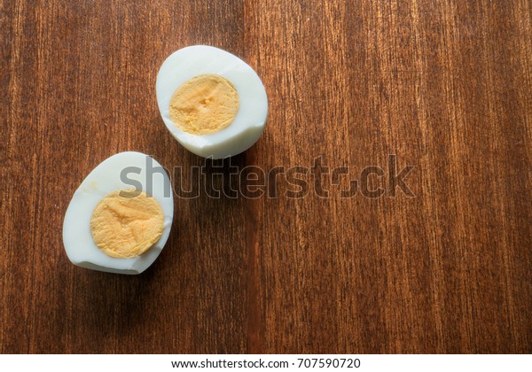 Hard\
boiled egg divided in half on wooden dining\
table