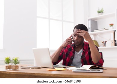 Hard call. Young black businessman in casual has mobile phone talk in modern white office interior. - Shutterstock ID 646845598