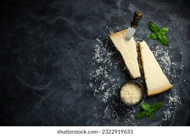 Hard cheese with basil on a dark background, Hard cheese, place for text top view. - Powered by Shutterstock