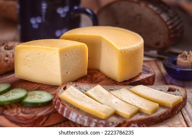 hard cheese with bread - still life with served slice of bread and sliced hard cheese loaf on a tray and chopping board