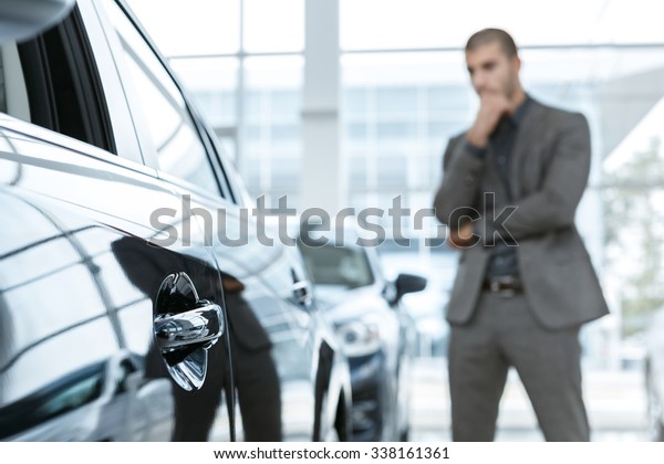 Hard choice. Selective focus on a car, man\
choosing car on the\
background