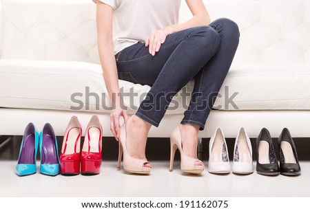 Hard choice. Woman deciding what shoes to choose.