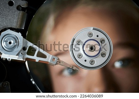 Hard disk drive inside. Data safety concept. Reflection of the child girl face as in a mirror