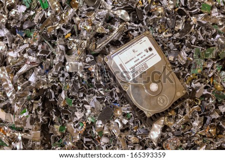 A hard drive resting on a pile of shredded hard drives