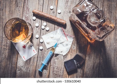 Drogen und Alkohol auf einem alten Holztisch