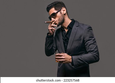 Hard gaze businessman while smoking a cuban cigar